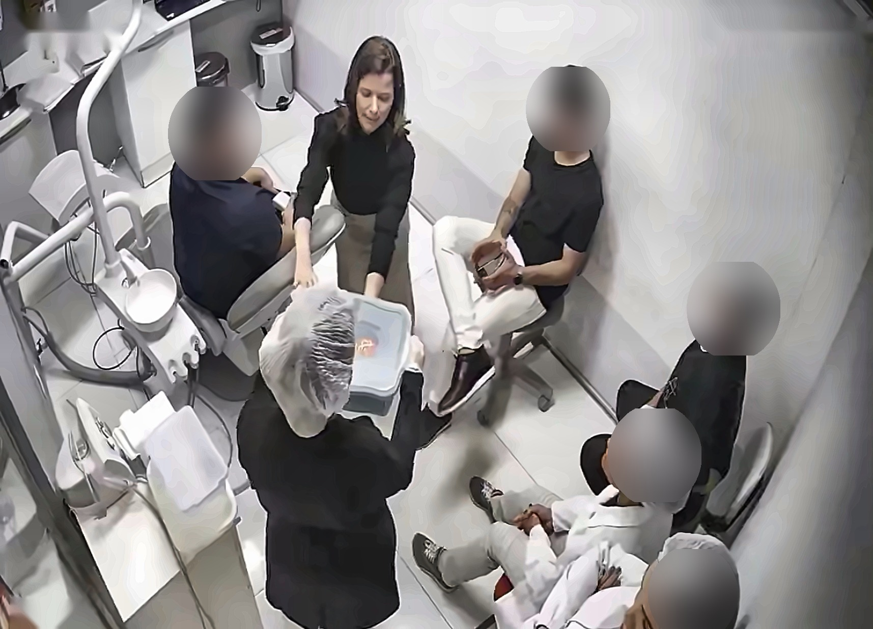Laila Campolina apresentando um documento durante um treinamento em uma clínica odontológica, em foto capturada por câmera de monitoramento